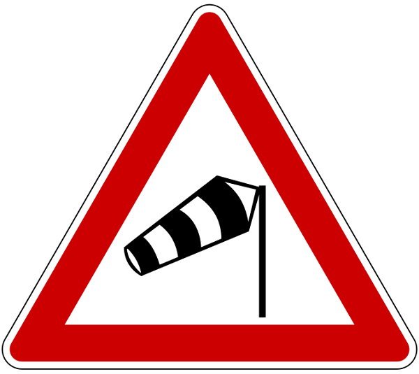 Señal de carretera de peligro por viento cruzado.
